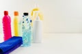 Plastic bottles of cleaning products set with pile clothes on white table background Royalty Free Stock Photo