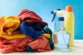 Plastic bottles of cleaning products set with pile clothes on white table background Royalty Free Stock Photo