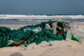 Old fishing net thrown to the seashore. trash on the sea beach. ecological problem. Environmental pollution