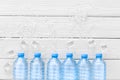 Plastic bottles with pure water and ice on white wooden background top view space for text Royalty Free Stock Photo
