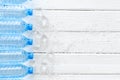 Plastic bottles with pure water and ice on white wooden background top view space for text Royalty Free Stock Photo