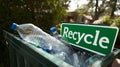 Plastic bottles in recycling bin with green recycle sign outdoors Royalty Free Stock Photo