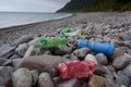 Plastic bottles rotting on beach, North Wales, UK