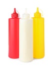 Plastic bottles of mayonnaise, ketchup and mustard on white background