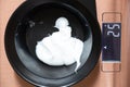 In a plastic bowl, hair keratin is weighed on a scale, hair keratin in a bowl on a scale, table scales