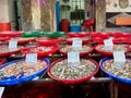 Plastic bowls with delectable fresh shellfish standing on stall in market