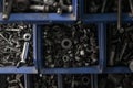 Plastic box with a bunch of nuts, bolts and screws. Tools and fasteners in the workshop. Construction and industry Royalty Free Stock Photo