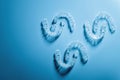 plastic braces in the shape of a pattern lie on a blue background, dental care and health