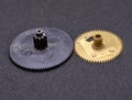 Plastic and brass gears on black background, close up