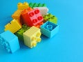 Plastic bricks, blocks toy on bright blue background.