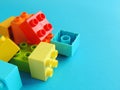 Plastic bricks, blocks toy on bright blue background.