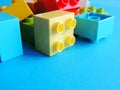 Plastic bricks, blocks toy on bright blue background. Royalty Free Stock Photo