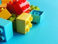 Plastic bricks, blocks toy on bright blue background. Royalty Free Stock Photo