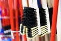 Plastic brushes for cleaning premises. Assortment of multi-colored brooms in the store. Close-up Royalty Free Stock Photo