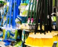 Plastic brushes for cleaning premises. Assortment of multi-colored brooms in the store. Close-up Royalty Free Stock Photo