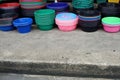 A plastic bucket and plastic cup on the concrete floor near a streest