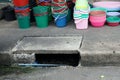 A plastic bucket and plastic cup on the concrete floor near a streest for sale