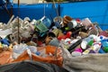 Plastic buckets, chairs, bottles, laundry baskets stacked in recycling facility