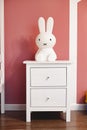 Plastic bunny night light sitting on white bedside table in kid room Royalty Free Stock Photo