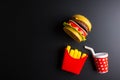 Plastic burger, French fries Fast food on black background. Children& x27;s toy. Concept of harmful artificial food. Plastic. Not Royalty Free Stock Photo