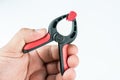 Plastic carpenters pinch tool in the hand above white background with copy space