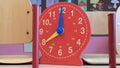 Plastic children`s analog clock in the classroom for interactive learning hours Royalty Free Stock Photo