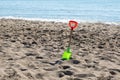 Plastic children`s toy on a deserted sandy beach. A shovel in the sand. The end of tourist season Royalty Free Stock Photo