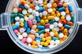 Plastic container with coloured pills on black background Royalty Free Stock Photo