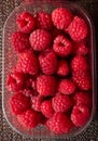 Plastic container full of fresh rasberries
