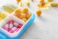 Plastic container with pills on white wooden table, closeup Royalty Free Stock Photo