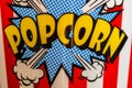 Plastic container for popcorn isolated close up photo. Popcorn sign on plastic and empty red and white striped bucket. Movie time