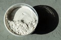 plastic container with white putty on a concrete background with hard lighting Royalty Free Stock Photo