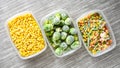 Plastic containers with frozen vegetables on grey background, top view, Different frozen vegetables on table, corn brussels Royalty Free Stock Photo