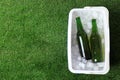 Plastic cool box with bottles of beer and ice cubes on green grass outdoors, top view. Space for text Royalty Free Stock Photo