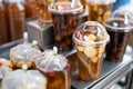A plastic cup and plastic bag of cold assorted beans, lotus roots, ginkgo, longan and sweet syrup in street food shop in asian for