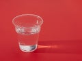 Plastic cup of fresh water over red,sidelit