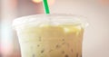 Plastic cup of Iced matcha with green straw in creamy tone