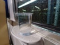 Plastic Cup of Mineral Water on Train Table with Raindrops on Window Background Royalty Free Stock Photo