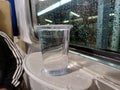 Plastic Cup of Mineral Water on Train Table with Raindrops on Window Background Royalty Free Stock Photo