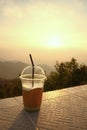 Plastic cup with straw on mountain layers background