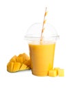 Plastic cup of tasty mango smoothie and fresh fruit on white background Royalty Free Stock Photo