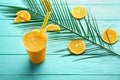 Plastic cup of tasty orange smoothie on color wooden table Royalty Free Stock Photo