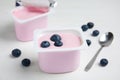 Plastic cup with tasty yogurt and blueberries on white wooden table Royalty Free Stock Photo