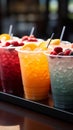 Plastic cups hold frozen fruit slushies, aligned in a colorful, frosty row