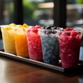 Plastic cups hold frozen fruit slushies, aligned in a colorful, frosty row Royalty Free Stock Photo