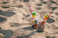 Plastic cups with straw and tropical decor and Garbage on the beach, trash, plastic, bottle, foam, rubbish, sigarette stub.