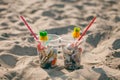 Plastic cups with straw and tropical decor and Garbage on the beach, trash, plastic, bottle, foam, rubbish, sigarette stub.