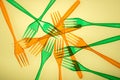 Plastic cutlery forks in colored orange and green colors on a yellow background Royalty Free Stock Photo
