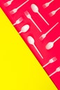 Plastic cutlery, forks, spoons on neon pink