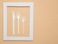 Plastic cutlery for picnics in a white frame on a blue background. A disposable spoon, fork, knife. Top view, minimalistic trend.. Royalty Free Stock Photo